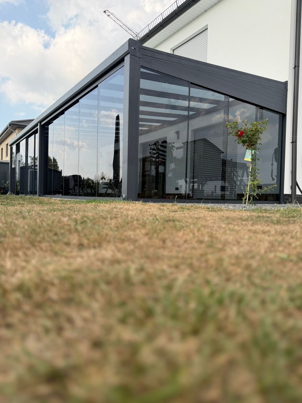 Rahmenlose Glasschiebewand vom Garten aus gesehen