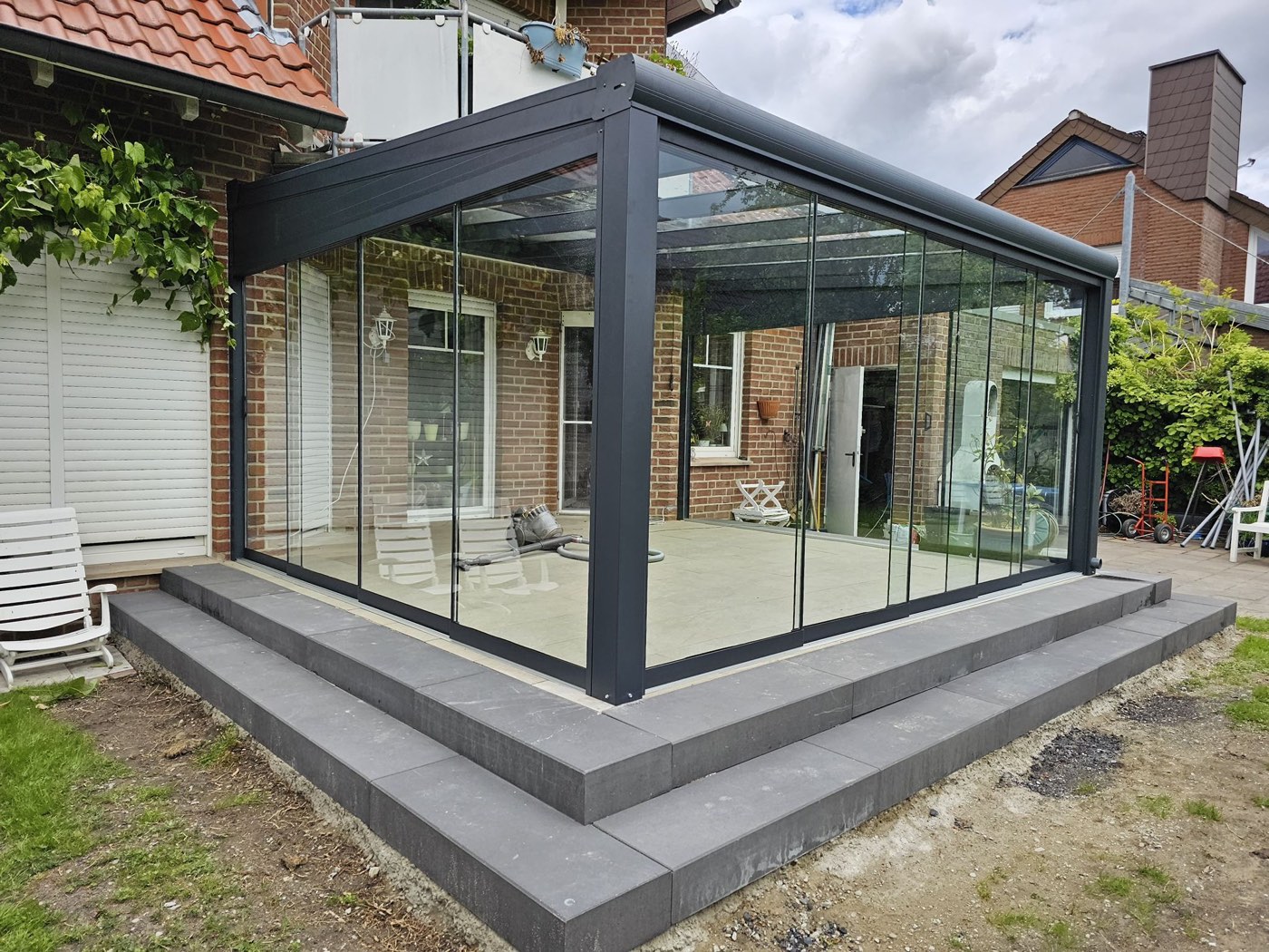 Wintergarten über Eck mit rahmenlosen Glasschiebewänden